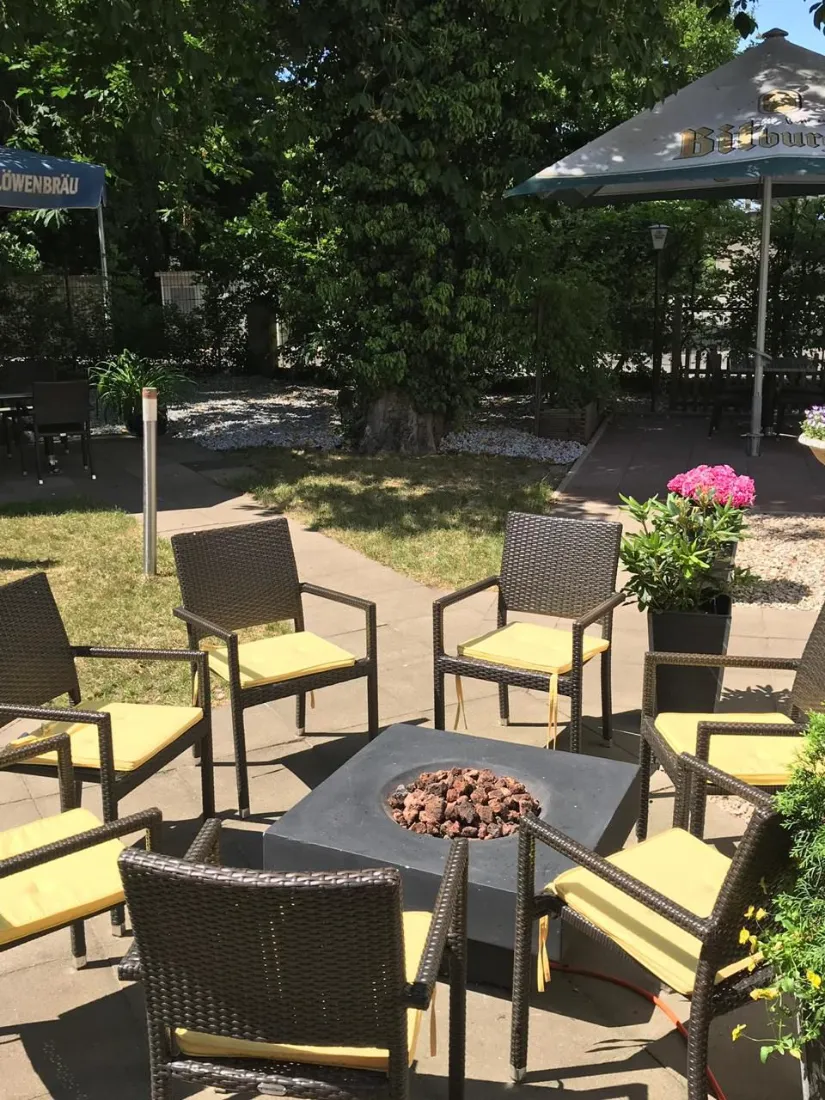 Biergarten des Ristorante Da Adriano in Lage — Sitzplätze im Freien unter Bäumen